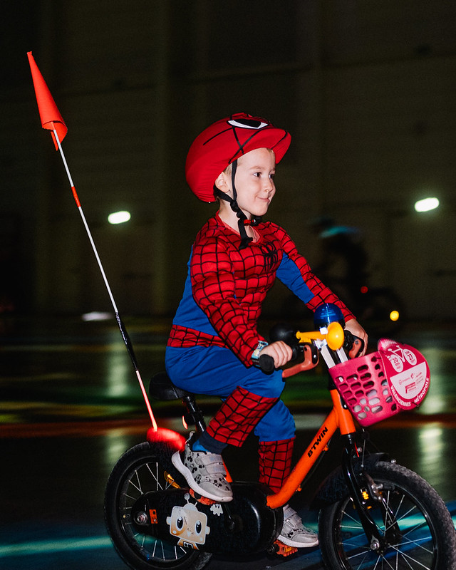 Enfant Vélotour déguisé en Spider-Man sur un vélo avec fanion et klaxon