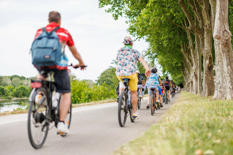 Famille de cyclistes, en file indienne qui parcourt la Loire à vélo lors d'une belle balade à vélo en France